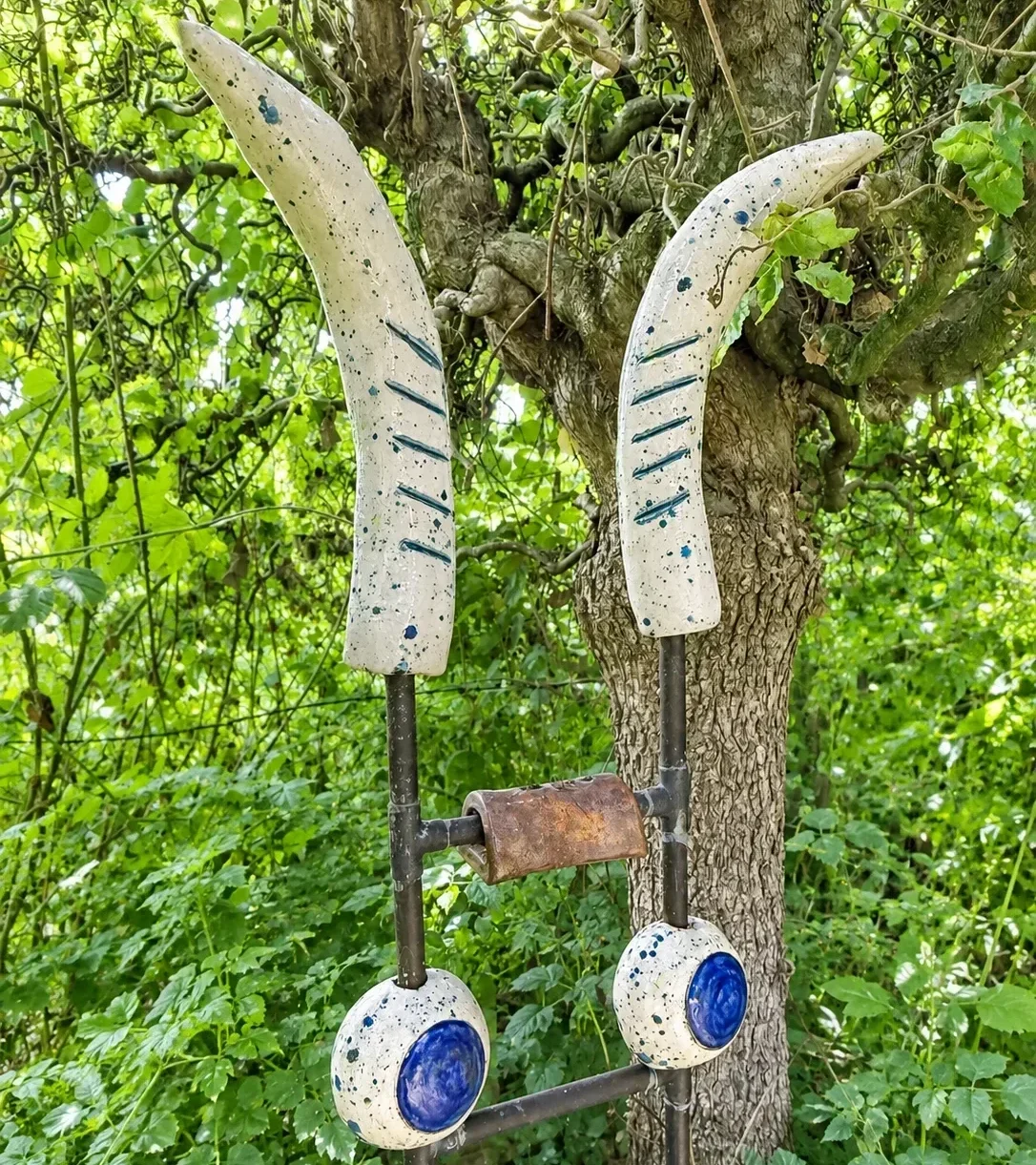 KERAMIKATUR „Der Gehörnte“ mit zwei langen keramischen Hörnern und Metallkonstruktion.