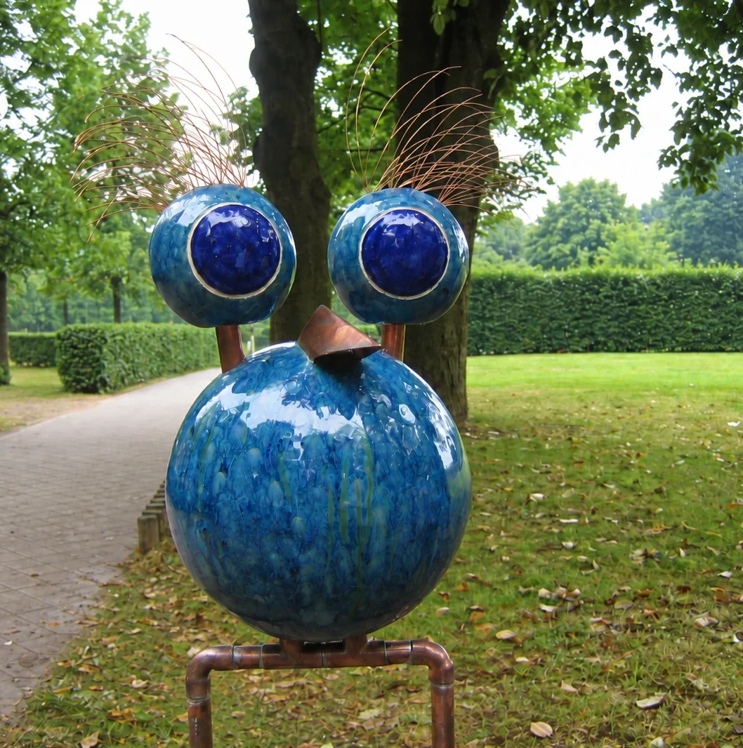 Eine weise KERAMIKATUR mit keramischem Kopf, markantem Schnabel, Metallelementen und beweglichen Augen.